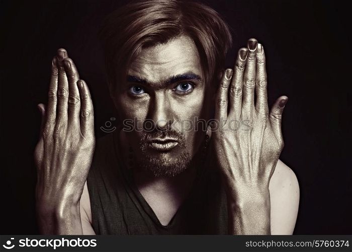 young attractive blue-eyed men with gold makeup on her face and stylish hairstyle on black background