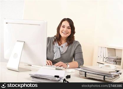 Young attractive business woman working at office with computer