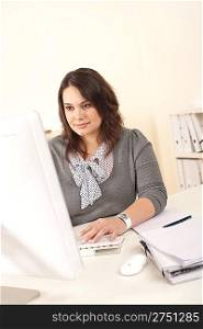 Young attractive business woman working at office with computer