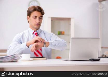 Young attractive businessman working in the office  