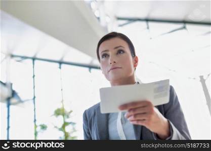 Young attractive businesswoman holding her boarding pass in airport