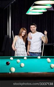 Young attractive couple at a billiard table