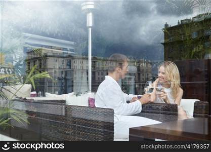 Young attractive couple behind glass in a restaurant