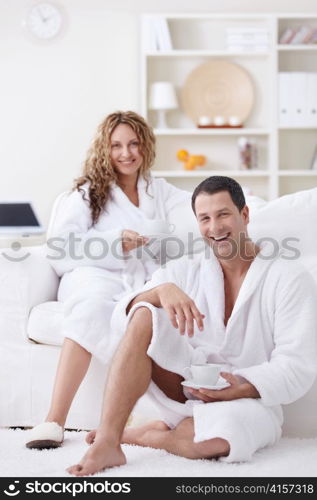 Young attractive couple drinking coffee at home