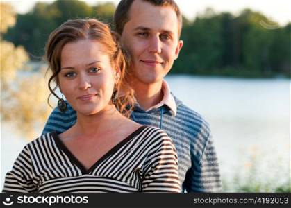 young attractive couple near lake at sunny weather