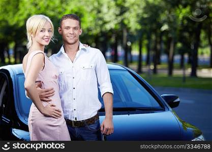 Young attractive couple next to car
