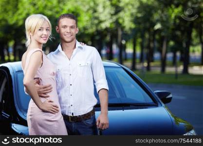 Young attractive couple next to car