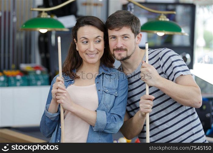 young attractive couple on date in snooker club