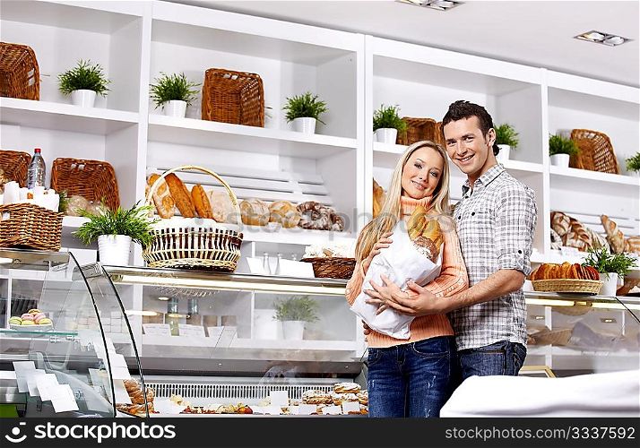 Young attractive couple with a package of rolls in shop