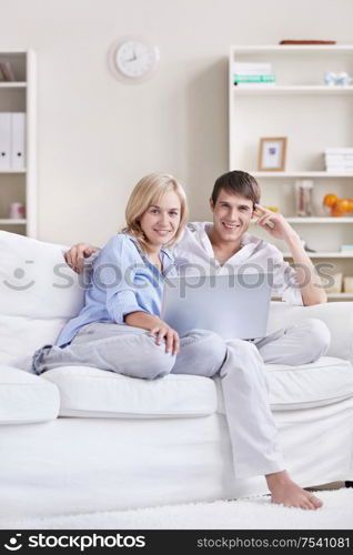 Young attractive couple with laptop at home