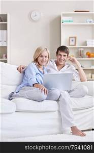 Young attractive couple with laptop at home