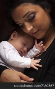 Young Attractive Ethnic Woman Holding Her Newborn Baby Under Dramatic Lighting.