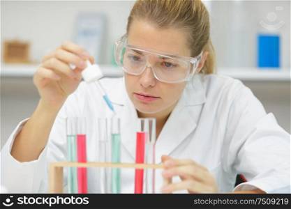young attractive female scientist holding a flask with liquid
