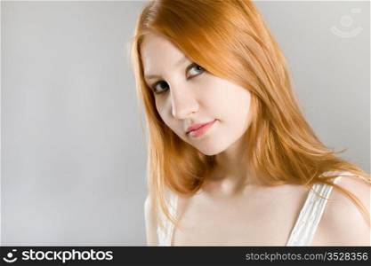 young attractive girl in a white dress on a gray background