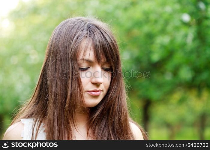 Young attractive girl in the garden. Face closeup