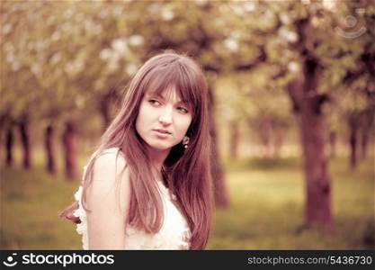 Young attractive girl in the garden. Toned in pink