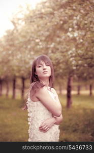 Young attractive girl in the garden. Toned in pink