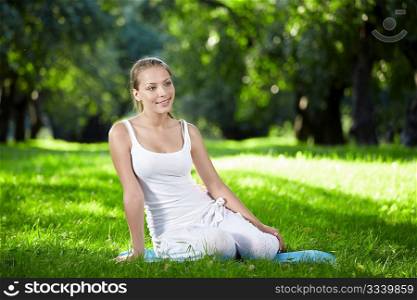 Young attractive girl sitting on the grass