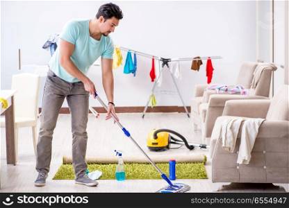 Young attractive man husband doing mopping at home. Young attractive man husband doing mopping at home