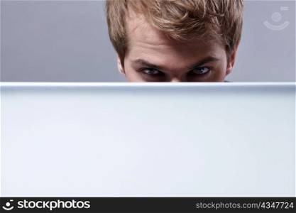 Young attractive man looks out for the laptop