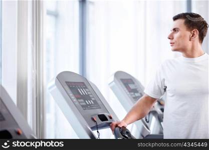 Young attractive man on a treadmill