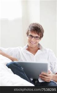 Young attractive man with laptop on sofa