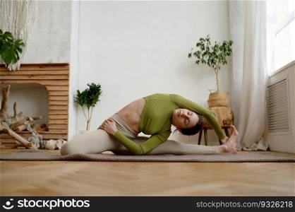 Young attractive mindful woman in sporty outfit practicing Parshva Janu Shirshasana sitting in head on knee yoga pose. Young attractive woman practicing Parshva Janu Shirshasana