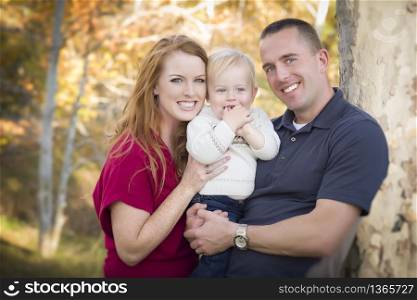 Young Attractive Parents and Child Portrait Outdoors.