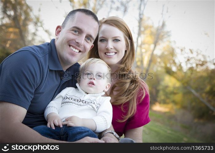 Young Attractive Parents and Child Portrait Outdoors at a Park.