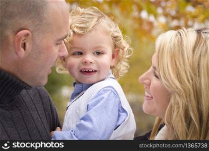 Young Attractive Parents and Child Portrait Outside in the Park.