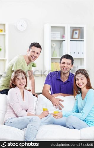 Young attractive people drink juice in the apartment