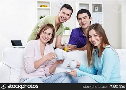 Young attractive people with drinks at home