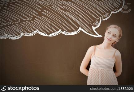 Young attractive thoughtful woman in dress standing at blackboard . Thinking woman and speech bubble