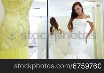 Young attractive woman choosing wedding shoes in bridal shop, posing and looking at camera