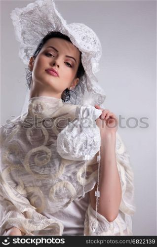 Young attractive woman dressed in fashionable handmade clothing on isolated background