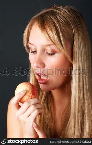 Young attractive woman eating ripe peach