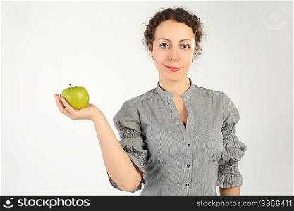 young attractive woman holding an apple in one hand, looking at camera, horizontal
