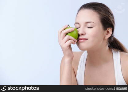 Young attractive woman holding an apple on a white background