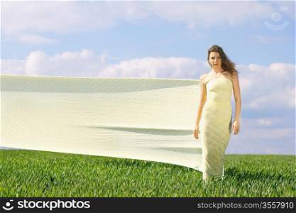 Young attractive woman in a green field