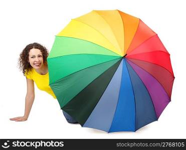 young attractive woman in yellow shirt sitting on white background and looking out of multicolored umbrella isolated