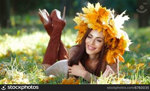 Young attractive woman posing in the autumn park, looking at camera