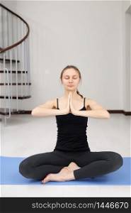 Young attractive woman practicing yoga, yoga studio. quarantine sports. Woman training and practicing yoga at class. Girl doing exercises at home. Young attractive woman practicing yoga, yoga studio. quarantine sports. Woman training and practicing yoga at class. Girl doing exercises at home.
