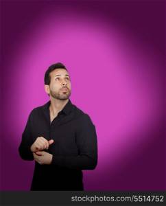 Young bearded businessman buttoning his shirt button on purple background