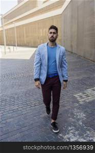 Young bearded man, model of fashion, in urban background wearing casual clothes.