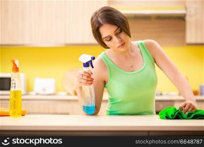 Young beatifull woman polishing table in the kitchen 