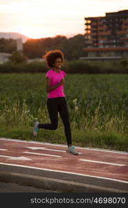 young beautiful African American woman enjoys running outside beautiful summer evening in the city