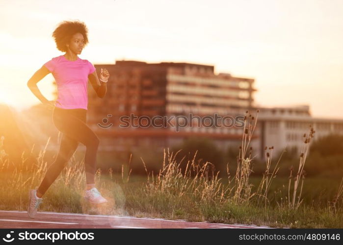 young beautiful African American woman enjoys running outside beautiful summer evening in the city