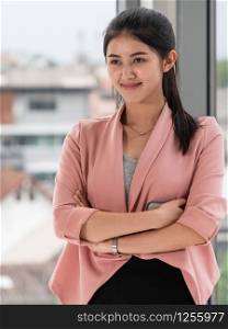 Young beautiful Asian business woman standing in office.
