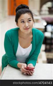 Young beautiful asian holding a cell phone