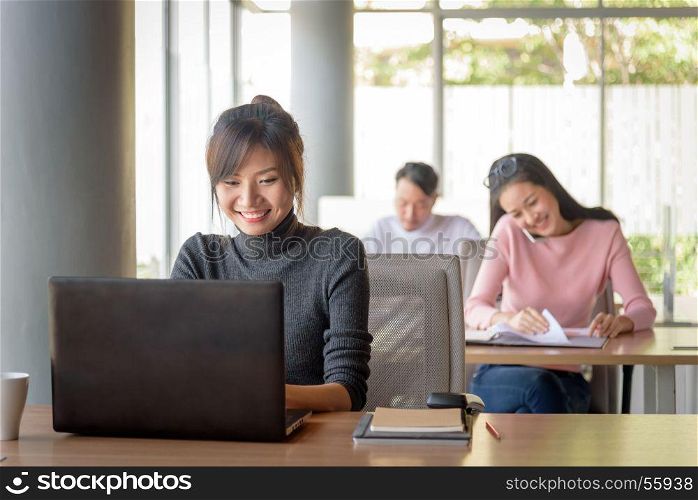 young beautiful asian smiling businesswoman working in startup office, happy work concept